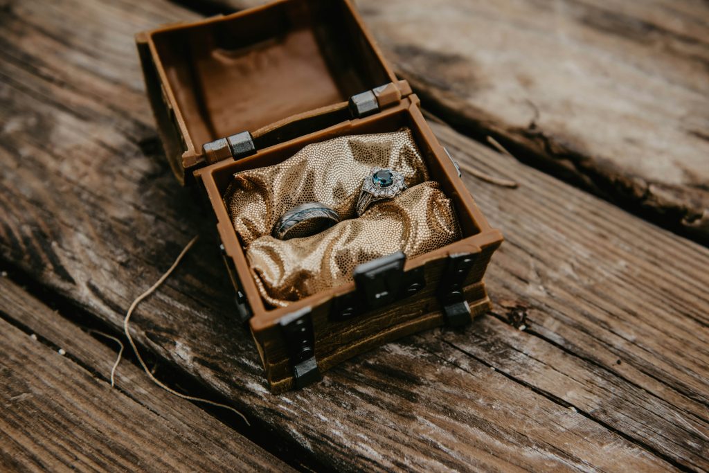 Wedding rings in a box with a wooden rustic background.